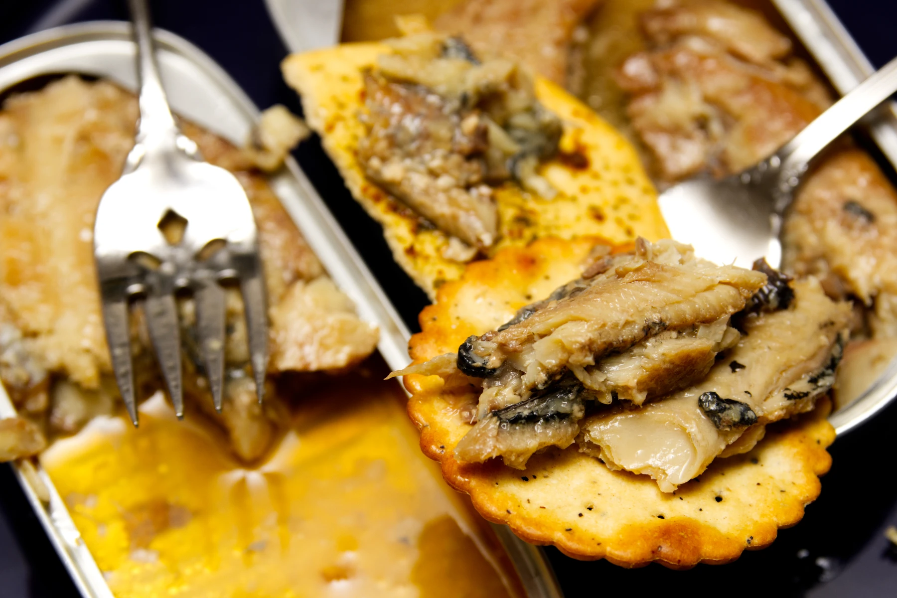 Closeup of a morsel of herring on a cracker