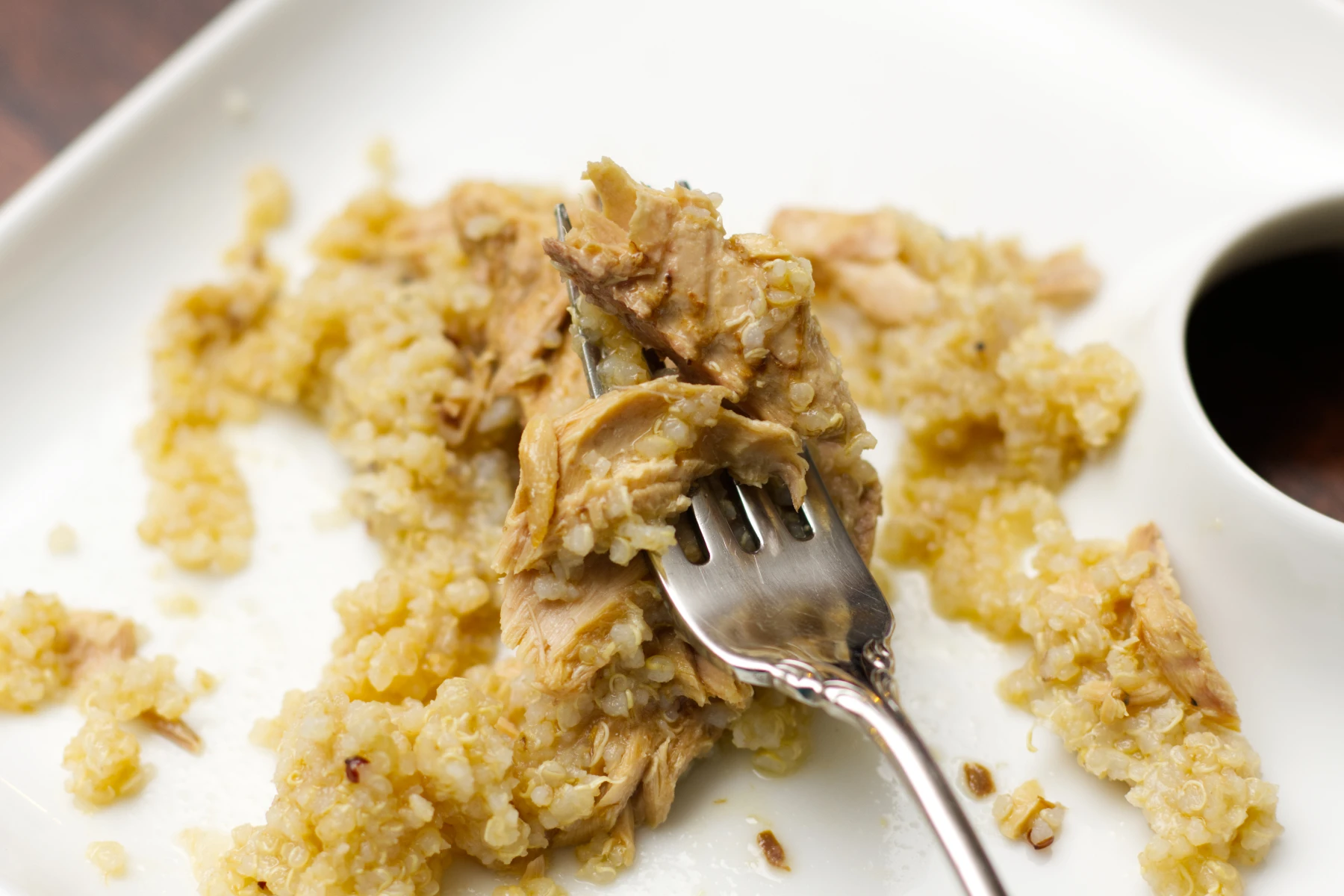 Mackerel pieces on a fork with some quinoa.