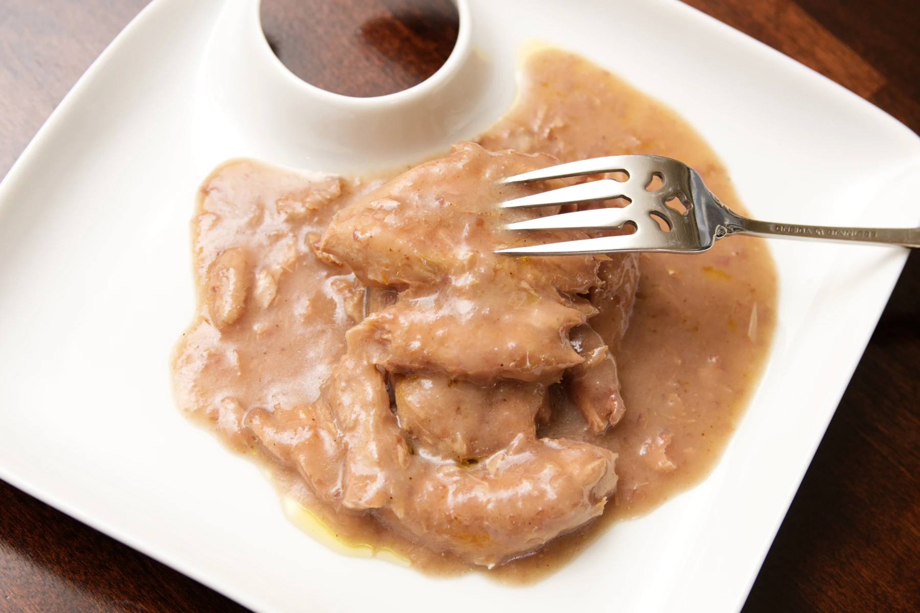 Mackerel fillets covered in Botija olive sauce on a plate.