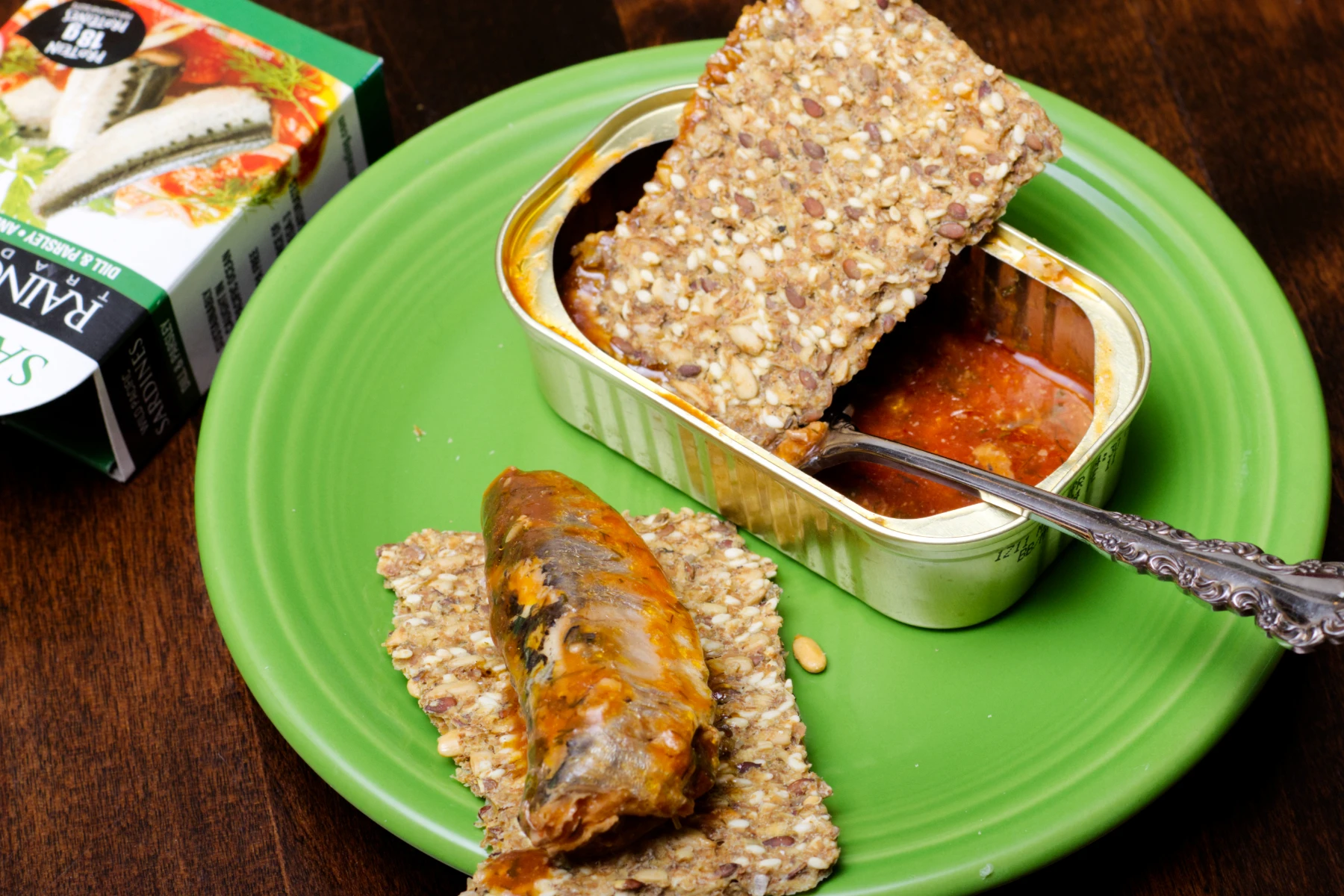 The last fish 'bullet' resting on a piece of crispbread, with another piece of crispbread in the tin soaking up the sauce.