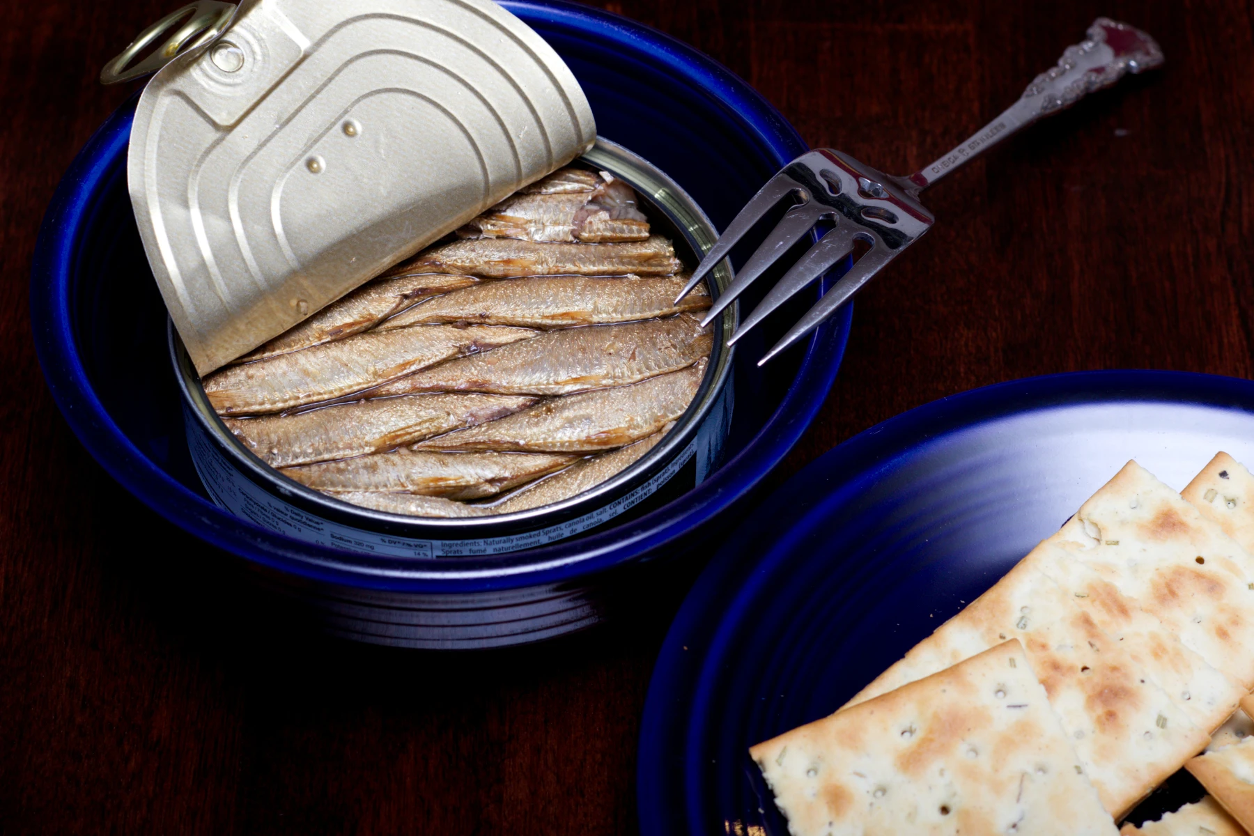 An open can of sprats showcasing the criss-crossed pattern of fish.