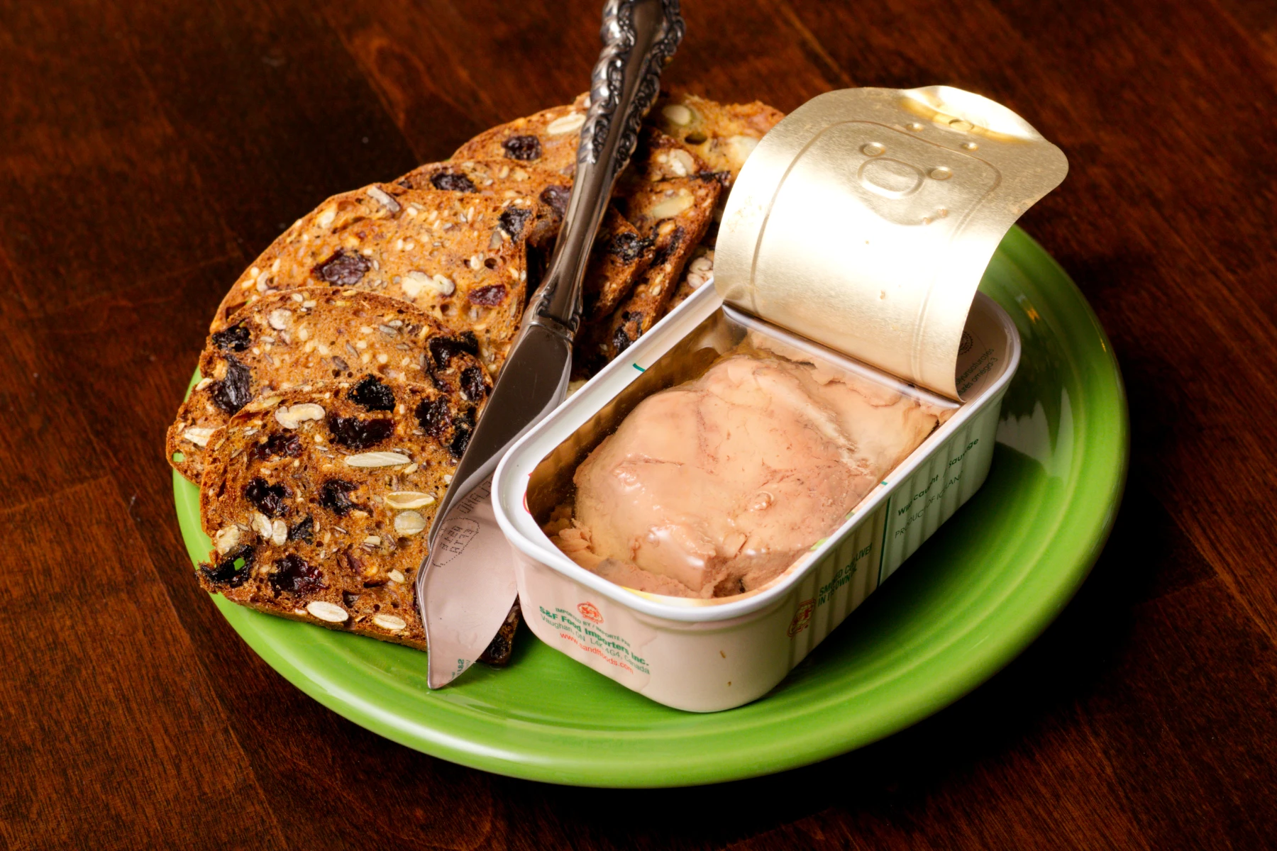 Opened tin on a plate with crackers